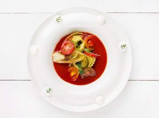 Sladká tomatová polévka, raviola s crème frâiche, grilovaná čekanka a bazalkový olej2